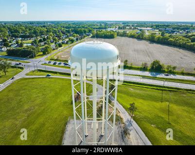 Antenna sul retro di una torre d'acqua bianca su lastra di cemento in estate che si affaccia su una strada Foto Stock