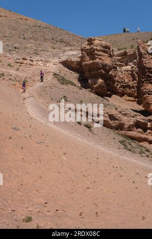 Kazakistan, Charyn (Sharyn) Canyon. I visitatori camminano lungo il sentiero nel Canyon dal Canyon Rim. Foto Stock