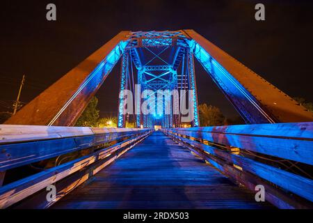 Luci blu al neon luminose su un ponte in legno all'interno del ponte ferroviario a capriata di notte in Ohio Foto Stock