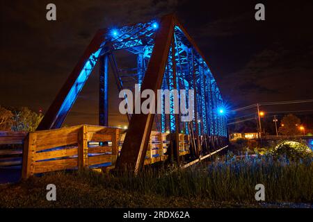 Foto notturna di luci al neon blu sul ponte del treno a capriata di Mount Vernon convertito in ponte pedonale Foto Stock