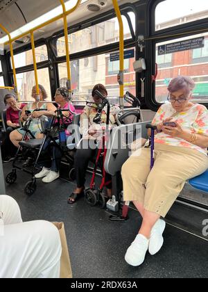 Molte persone anziane utilizzano il sistema di autobus pubblico e spesso hanno bisogno di ausili per camminare come canne o camminatori. Autobus MTA, Brooklyn, New York. Foto Stock