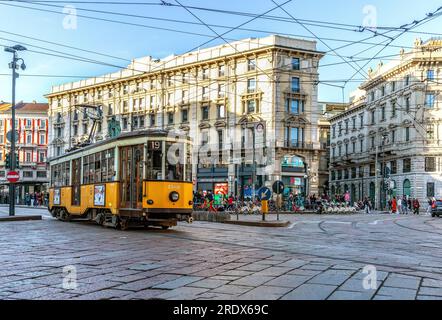 Tram giallo tradizionale e gente che cammina in piazza Cordusio, nel centro di Milano, in Lombardia, nel nord Italia. Foto Stock