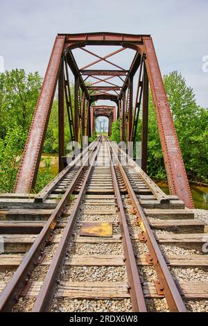 Foto verticale del ponte ferroviario di ferro con binari ferroviari sul fiume Kokosing Foto Stock