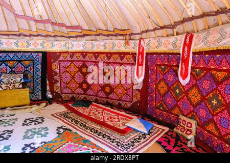 Kazakistan, Huns Ethno Village. Interni in yurta con decorazioni floreali e geometriche in tessuto. Foto Stock