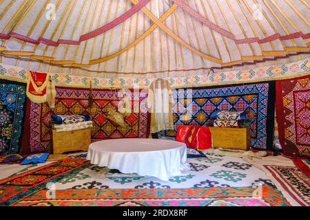 Kazakistan, Huns Ethno Village. Interni in yurta con decorazioni floreali e geometriche in tessuto. Foto Stock