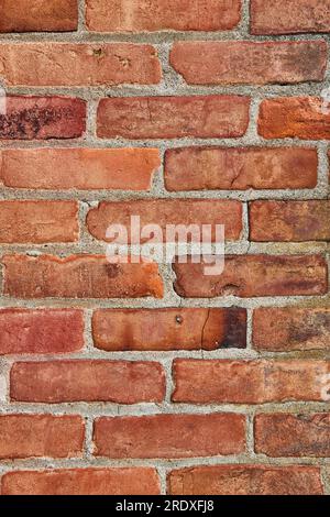 Immagine verticale di una risorsa di sfondo di mattoni rossi incrinati e sporchi o sporchi Foto Stock