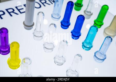 Preforme per bottiglie in plastica PET prima dello stampaggio a soffiaggio. Industria dell'imballaggio. Preforme PET dalla pressa per stampaggio a iniezione delle preforme. Materia prima per bottiglie in PET Foto Stock