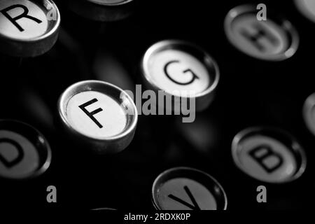 Alcuni tasti sono visibili su una classica macchina da scrivere anni '1920 con sfondo nero ricco. Adatto per uffici aziendali e camere d'hotel. Foto Stock