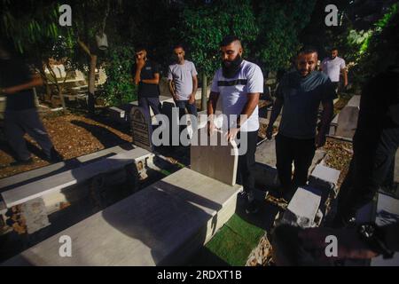 Nablus, Palestina. 23 luglio 2023. Un prigioniero palestinese liberato, Dean Kaddoura, visita per la prima volta la tomba di sua madre, che morì mentre era imprigionato, dopo il suo rilascio da parte delle autorità israeliane, nella città di Balata, a est di Nablus, in Cisgiordania. Il palestinese in mezzo era prigioniero nelle prigioni israeliane. Credito: SOPA Images Limited/Alamy Live News Foto Stock