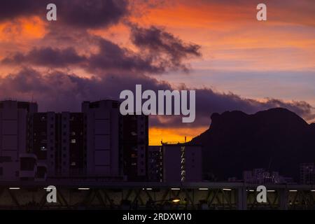 Il famoso punto di riferimento di Kowloon, la montagna Lion Rock, si trova sul lato destro e gli alloggi pubblici sul lato sinistro, con lo sfondo del tramonto. Foto Stock