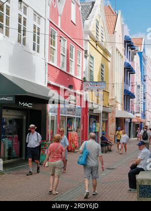 I turisti camminano lungo Heerenstraat, una vecchia strada tradizionale che guarda i negozi di Willemstad, Curacao, Antille olandesi Foto Stock