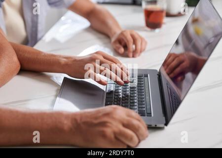 Immagine ravvicinata di un giovane che mostra al padre anziano come inviare e-mail Foto Stock