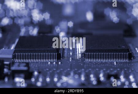 Primo piano della scheda a circuito stampato con processore, circuiti integrati e molti altri componenti elettrici passivi a montaggio superficiale. Foto Stock