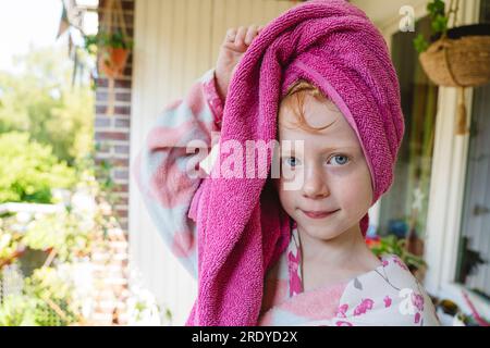 Ragazza con un asciugamano avvolto sulla testa nel balcone Foto Stock