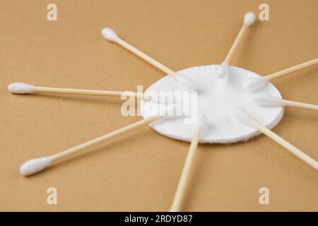 Diversi batuffoli di cotone si trovano su un batuffolo di cotone come il sole, su uno sfondo beige di carta artigianale. Vista laterale Foto Stock