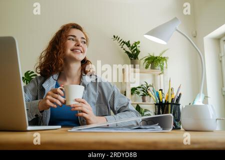 Giovane e premuroso freelance seduto con una tazza di caffè a casa Foto Stock