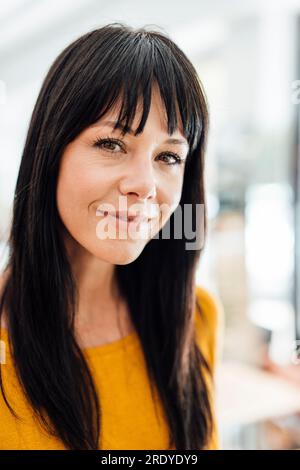 Donna matura sorridente con le battute dei capelli Foto Stock