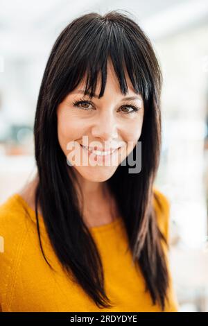 Donna sorridente con le battute dei capelli Foto Stock