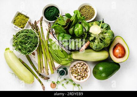 Cibo verde sano vegetariano su sfondo bianco. Prodotti per vegani e vegetariani con proteine. Piselli verdi, fagioli, fagioli mung, broccoli, zucchine Foto Stock