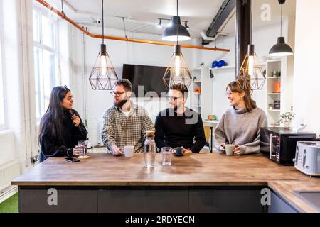 Uomini d'affari felici e donne d'affari che si prendono una pausa e parlano tra loro Foto Stock