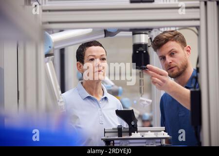 Il tecnico spiega la parte della macchina al collega del settore Foto Stock