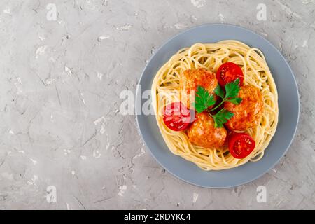 Pasta e polpette speziate stufate in salsa di pomodoro servite su piatto grigio Foto Stock