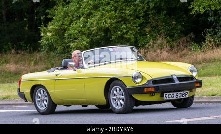 Milton Keynes, Regno Unito - 21 luglio 2023: 1976 MG B gialla, auto a tetto aperto che guida su una strada inglese Foto Stock