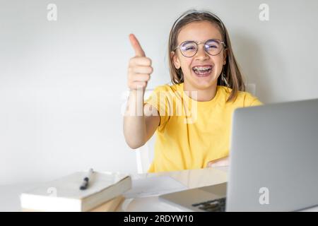 Carina studentessa con un portatile che studia a casa, impara online. Foto Stock