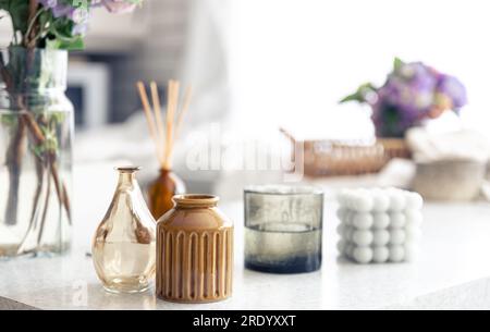 Vasi e candele su uno sfondo sfocato di un interno domestico. Foto Stock