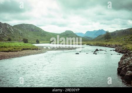 il selvaggio fiume di salmone si snoda attraverso le montagne degli altopiani scozzesi Foto Stock