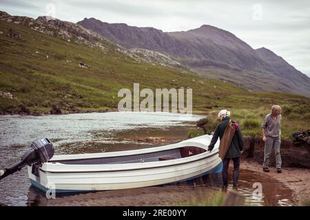 due donne con barca in remoto fiume per la pesca del salmone attraverso le montagne Foto Stock