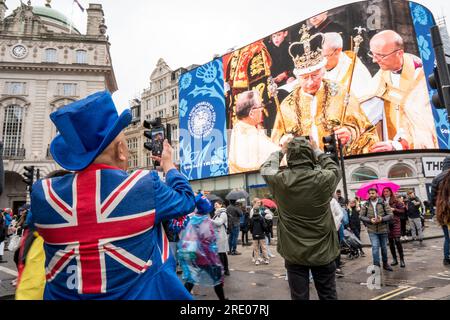 Gente che si riunisce al Piccadilly Circus per celerbrare l'Incoronazione di Re carlo sul grande schermo Foto Stock