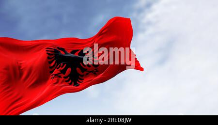 Bandiera nazionale albanese che sventola nel vento in una giornata limpida. Bandiera rossa con aquila nera a due teste. rendering dell'illustrazione 3d. Tessuto svolazzante. Foto Stock