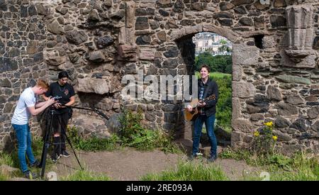 St Anthony's Chapel Holyrood Park, Edimburgo, Scozia, Regno Unito, 24 luglio 2023. Mike Baillie video musicale per Fringe show: Frontman della band The Lonely Together Films un nuovo video musicale per il suo debutto Fringe show Endless Sunset Oblivion che racconta la storia di un giovane cantautore Reuben che tenta di combattere i problemi accelerati che il mondo sta affrontando. La canzone nel video è stata scritta in questo luogo. Crediti: Sally Anderson/Alamy Live News Foto Stock