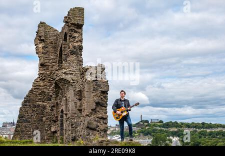 St Anthony's Chapel Holyrood Park, Edimburgo, Scozia, Regno Unito, 24 luglio 2023. Mike Baillie video musicale per Fringe show: Frontman della band The Lonely Together Films un nuovo video musicale per il suo debutto Fringe show Endless Sunset Oblivion che racconta la storia di un giovane cantautore Reuben che tenta di combattere i problemi accelerati che il mondo sta affrontando. La canzone nel video è stata scritta in questo luogo. Crediti: Sally Anderson/Alamy Live News Foto Stock