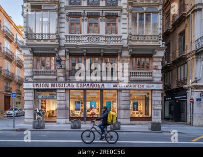 Fahrradfahrer in der Carrer de la Pau ist eine Einkaufsstrasse mit vielen GeschŠften in der Altstadt a Valencia *** i ciclisti in Carrer de la Pau sono a Foto Stock