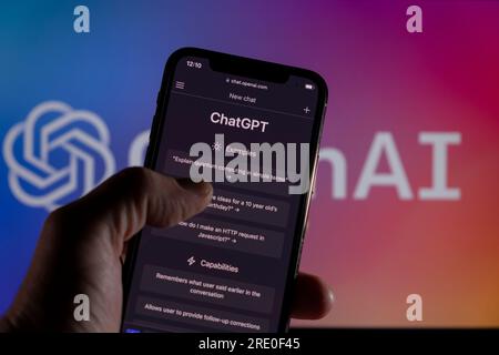 Azzorre, Portogallo - 21.01.2023: Smartphone con prompt OpenAI - ChatGPT e sullo sfondo sfocato il logo OpenAI sullo schermo di un notebook. Foto Stock