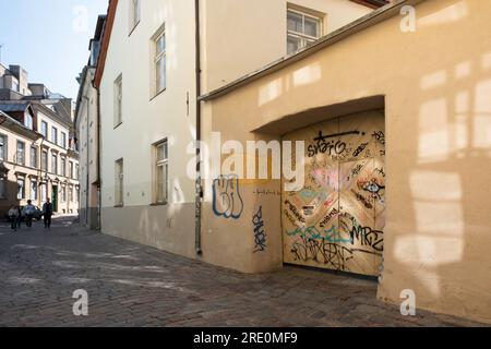 Paesaggio urbano di Tallinn. Case in via Muurivahe (Müürivahe) nel centro storico con graffiti sulle pareti e porta del garage Foto Stock