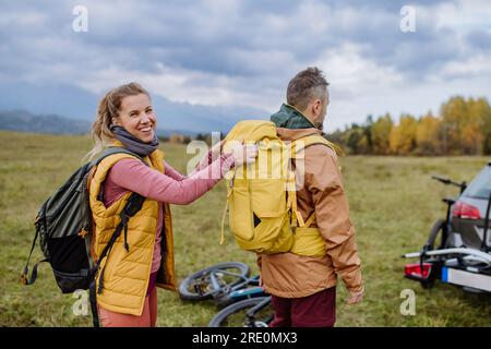 Coppia felice che si prepara per un giro in bicicletta nella natura, in mezzo alla natura autunnale. Foto Stock