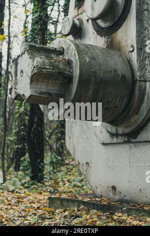 Dettaglio di una vecchia ed enorme macchina per la macinazione dei minerali nella foresta. Macchine abbandonate di storia industriale. Produzione di ferro e acciaio. Foto Stock