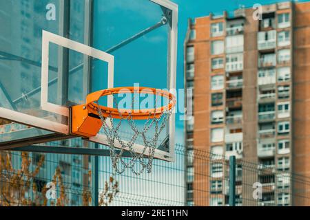 Backboard da basket all'aperto e cerchio con rete a catena nel quartiere residenziale urbano, focus selettivo Foto Stock