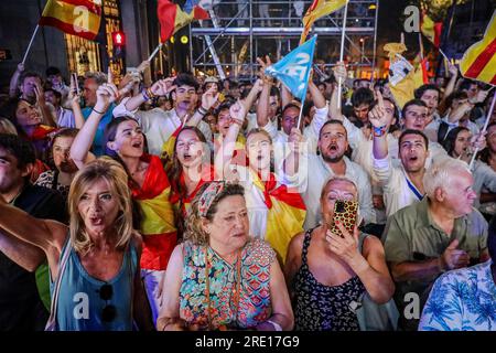 Madrid, Spagna. 23 luglio 2023. Un gruppo di sostenitori del Partito Popolare con bandiere spagnole celebrano la vittoria del loro partito presso la sede del PP durante il conteggio dei voti. Decine di persone si riuniscono a Calle Génova 13 alle porte del quartier generale del Partito Popolare (PP) per attendere i risultati delle elezioni generali spagnole, che il partito spagnolo di destra ha vinto con 136 seggi al Congresso oltre 122 per il Partito Socialista Operaio spagnolo (PSOE). Credito: SOPA Images Limited/Alamy Live News Foto Stock