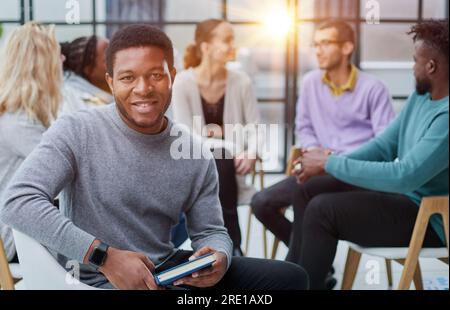 Ha riunito giovani uomini d'affari felici che hanno condotto i negoziati, incontrandosi con i colleghi differenti ed amichevoli Foto Stock