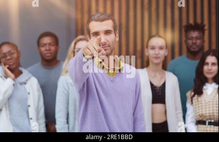 Il giovane uomo d'affari punta il dito indice verso la telecamera. Concetto di motivazione di invito all'azione Foto Stock