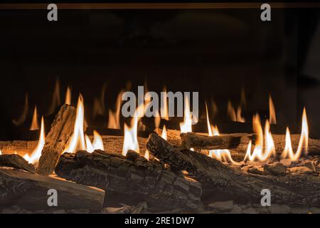 Caminetto a gas con vista ravvicinata sulla legna da ardere Foto Stock