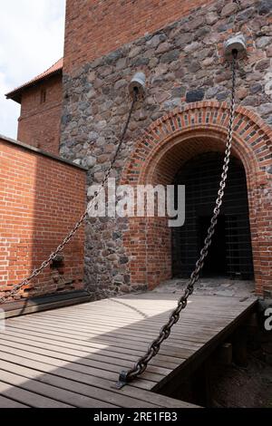 Ponte levatoio con catene presso il vecchio castello di Trakai sull'isola nel mezzo del lago Galve a Trakai, Lituania, Europa orientale Foto Stock