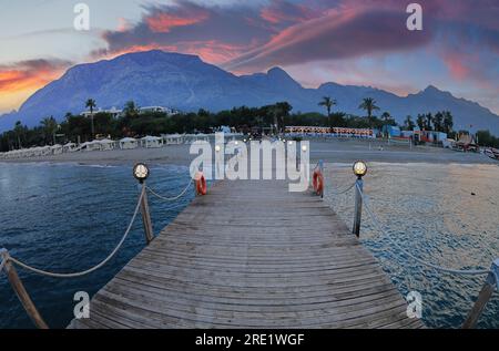 Vista sulla spiaggia della Riviera turca con le montagne del Tauro sullo sfondo. Al tramonto. Foto Stock