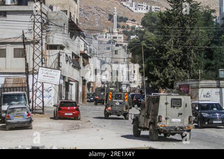 Nalus, Palestina. 24 luglio 2023. I rinforzi militari israeliani entrano nel campo profughi di Askar durante un'operazione militare all'interno del campo, a est di Nablus, nella Cisgiordania occupata. L'esercito israeliano fece irruzione nei campi di Nour Shams, ad est di Tulkarm, e Aqabat Jabr a Gerico, Askar, ad est di Nablus, durante un'operazione congiunta allo stesso tempo per arrestare persone ricercate. Credito: SOPA Images Limited/Alamy Live News Foto Stock