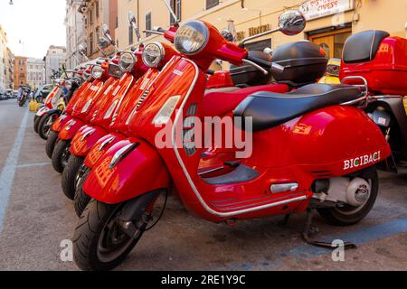 Roma, Italia - 17 giugno 2023: Gruppo di scooter Vespa rossi parcheggiati. Noleggio scooter in città. Foto Stock