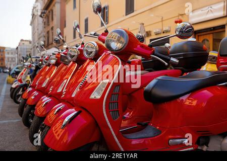 Scooter di colore rosso parcheggiati. Noleggio scooter in città. Foto Stock